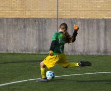 student kicking a football