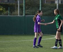 Female students sharing hands in football game